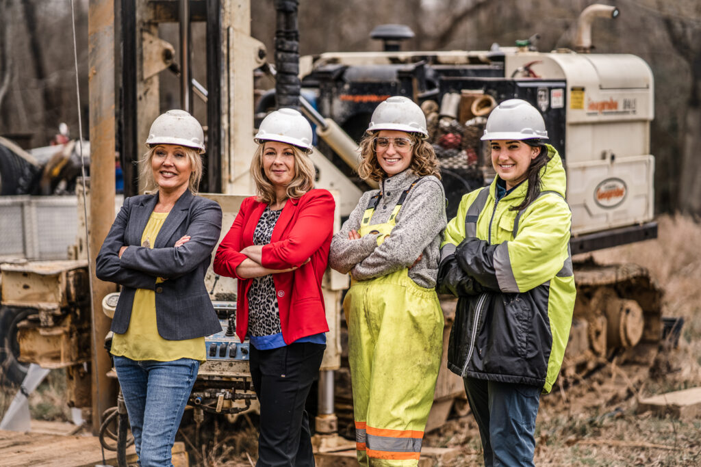 IperionX employees posed, smiling on site of the Titan Critical Minerals Project in Tennessee