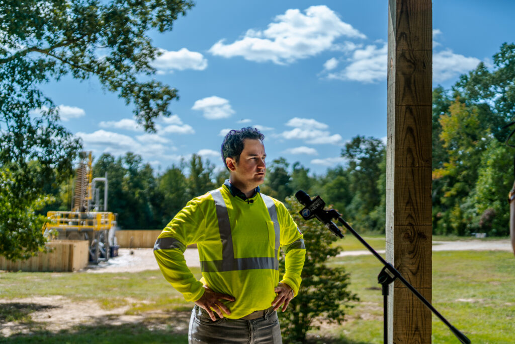 IperionX CEO Taso Arima standing in front of a microphone at the Titan Project in West Tennessee.